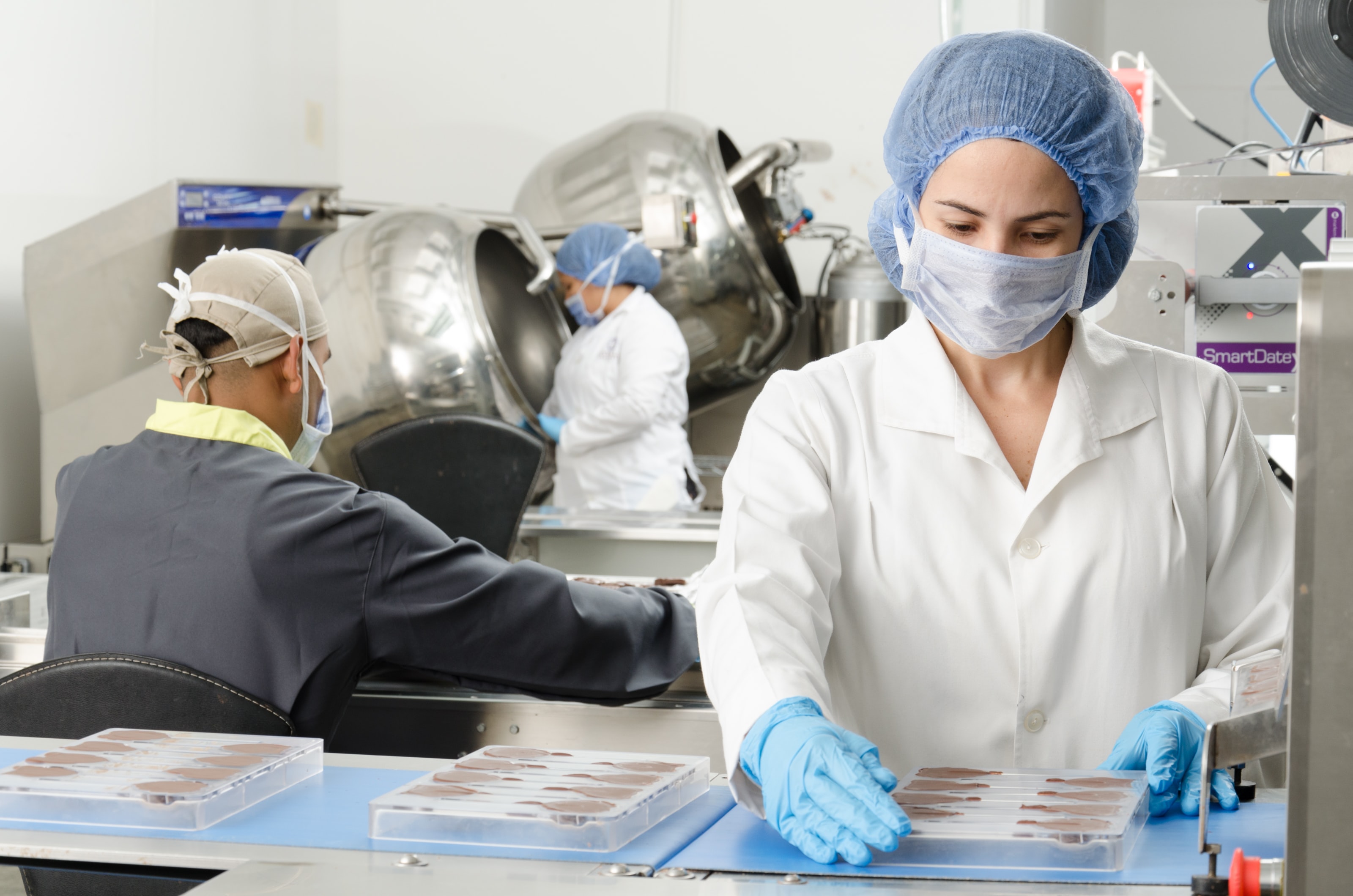 Personal de laboratorio manipulando productos alimentarios en un entorno controlado, relacionado con el índice de refracción en la industria
